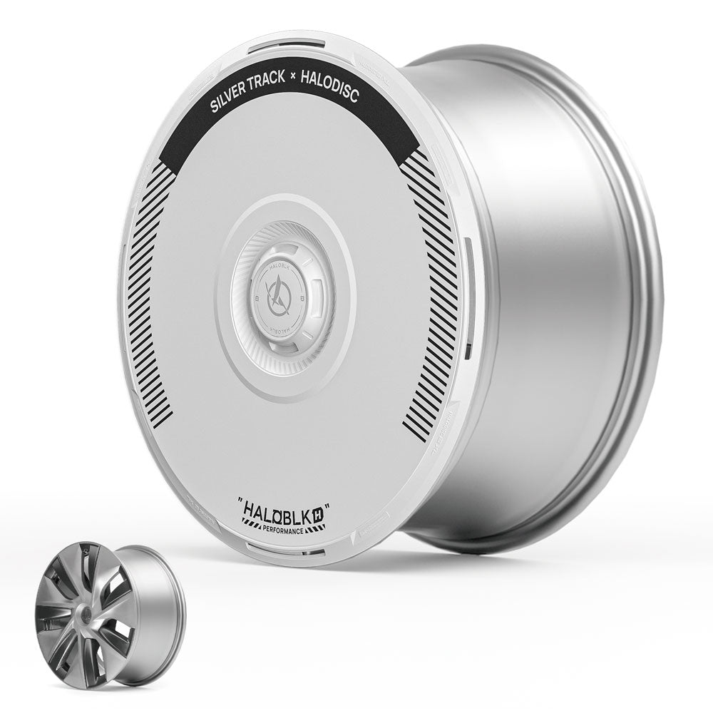 The HALOBLK Store’s HALODISC 2 Wheel Covers for Tesla Model 3 (2017-2018) 19" Power Sports Wheels in Silver Track are displayed upright; a smaller, traditional five-spoke rim is shown in the foreground for comparison.