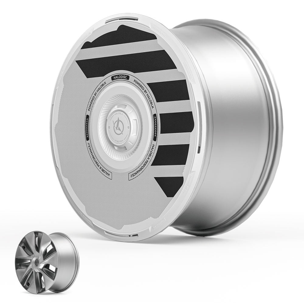 The HALODISC 2 Wheel Cover for Tesla Model 3 2017-2018 by HALOBLK Store is shown in silver with a white and black aerodynamic cover featuring bold diagonal stripes; a smaller alloy wheel appears at the lower left for comparison.