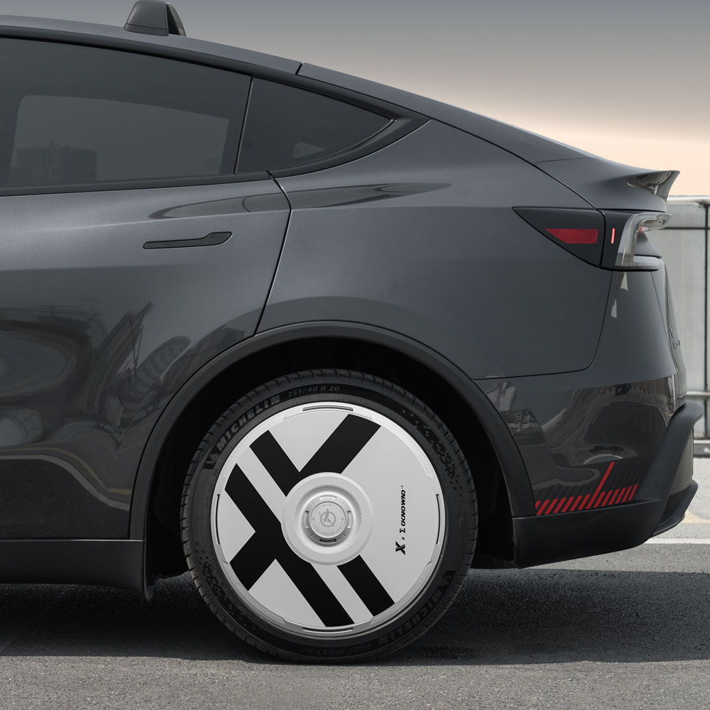 A close-up side view of a dark gray Tesla Model Y Juniper featuring HALODISC 2 Wheel Covers by HALOBLK Store, designed for 20" Helix 2.0 wheels with bold black diagonal stripes and X-Factor branding.