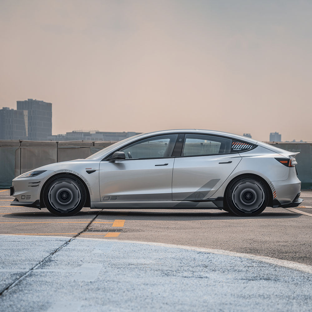 A Tesla Model 3 Highland with 18" Photon Wheels is parked on a rooftop, featuring HALODISC 2 Vision-GT wheel covers by HALOBLK Store, set against a hazy city skyline and pale sky.