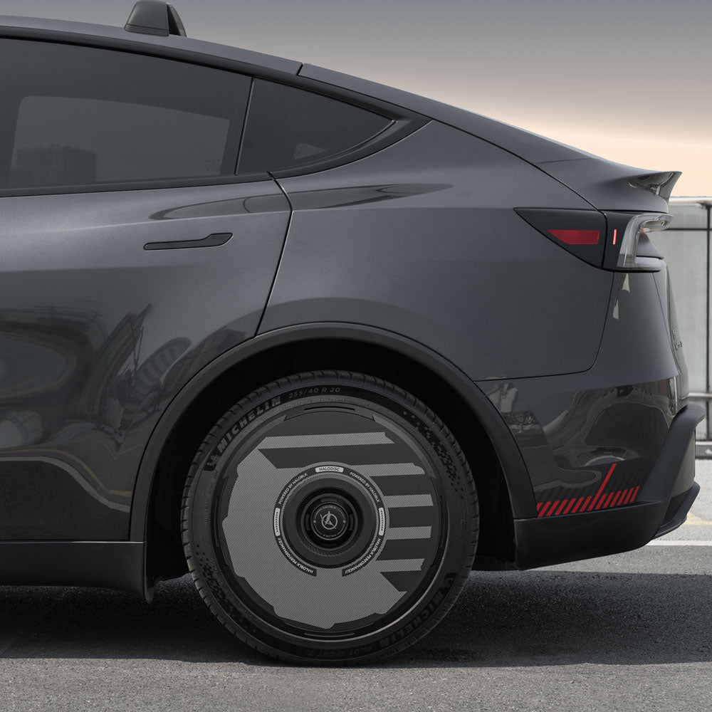 A close-up side view of a Tesla Model Y with HALODISC 2 Wheel Covers from HALOBLK Store installed on 19" Juniper Crossflow wheels, highlighting the modern black and gray aerodynamic rim design.