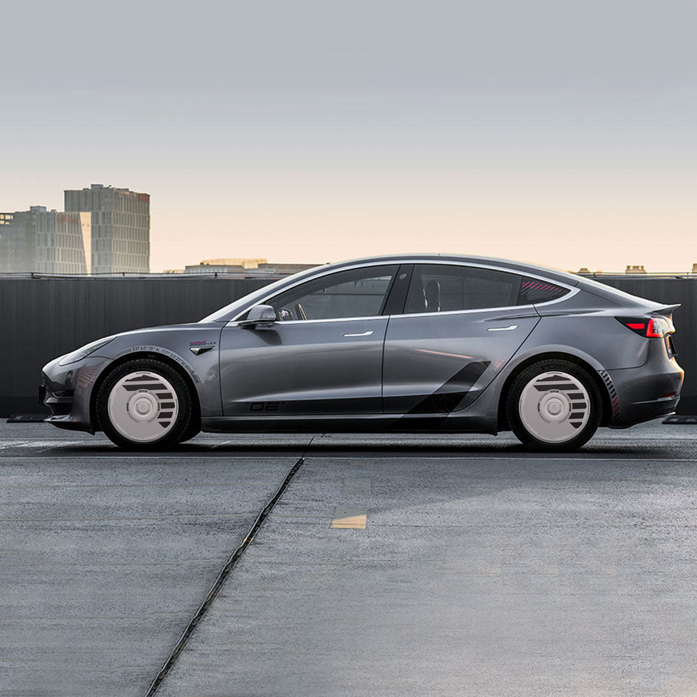 A Tesla Model 3 with futuristic HALODISC 2 Wheel Covers by HALOBLK Store is parked on a rooftop at sunset, featuring sleek silver styling and modern design. Fits Model 3 (2017-2023) with 18" Aero Wheels by H-Industry.