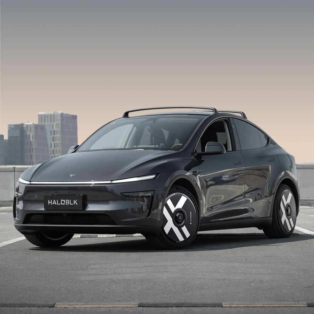 A Tesla Model Y with HALODISC 2 Wheel Covers (Juniper 20" Helix 2.0, X-Factor) from HALOBLK Store is parked on a rooftop, showcasing a modern, minimalist look and eye-catching wheels. The license plate reads HALOBLK.