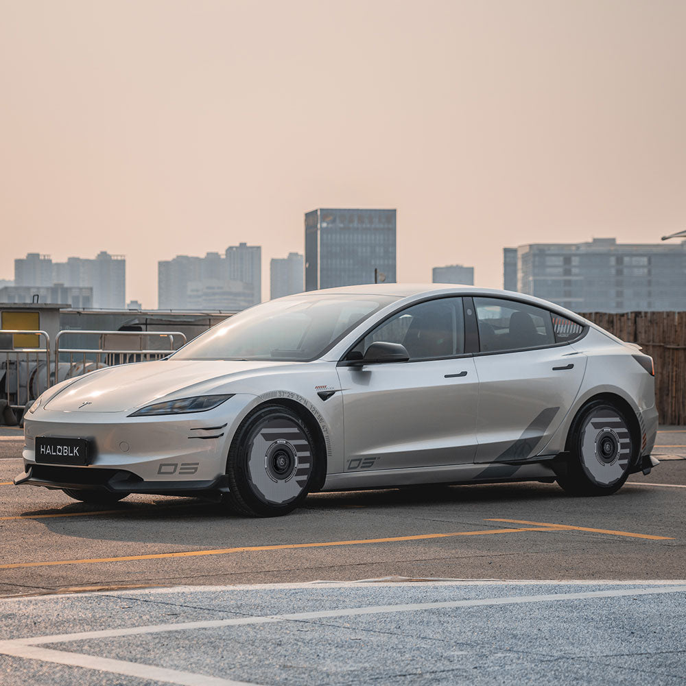 A Tesla Model 3 Highland with HALODISC 2 Wheel Covers by HALOBLK Store is parked on a rooftop with a city skyline in the background under a hazy sky, showcasing the 19" Nova Wheels.