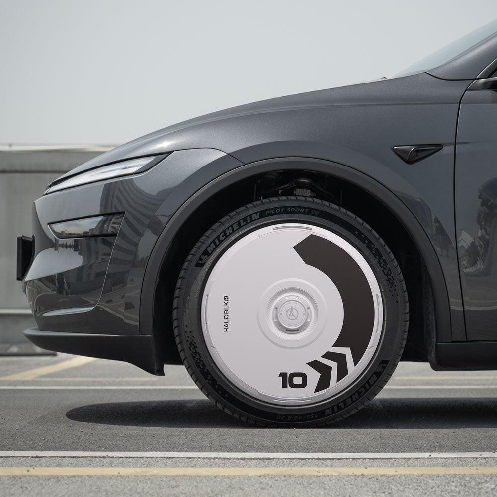 Close-up side view of a Tesla Model Y with HALODISC 2 Wheel Covers (Arrow) for Juniper 20" Helix 2.0 Wheels by HALOBLK Store, featuring bold black and gray graphics, the number 10, and a sleek geometric hubcap design.