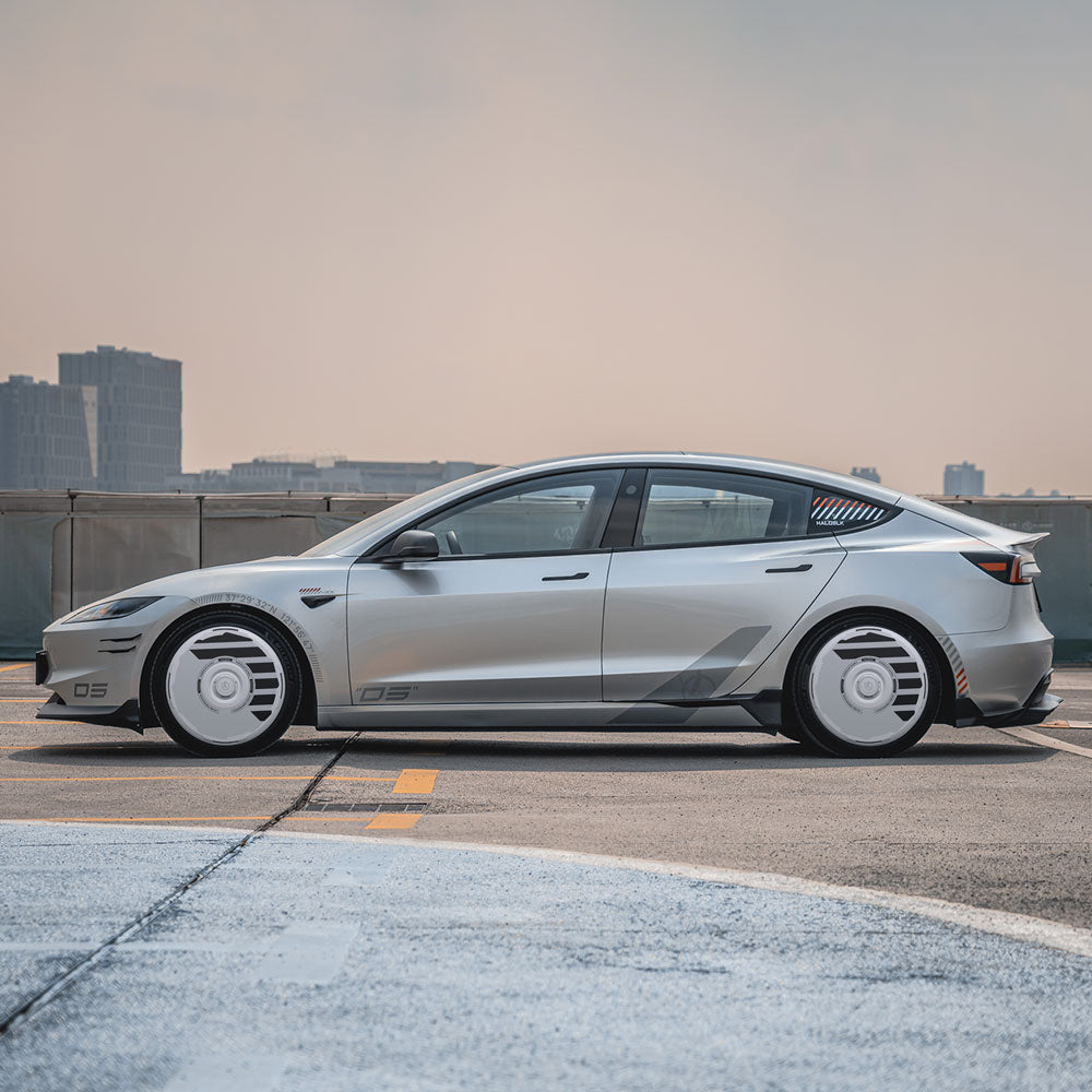A Tesla Model 3 Highland with 18" Photon Wheels is parked on a rooftop under a hazy sky, showcasing HALODISC 2 Wheel Covers from HALOBLK Store by H-Industry, with city buildings in the background.