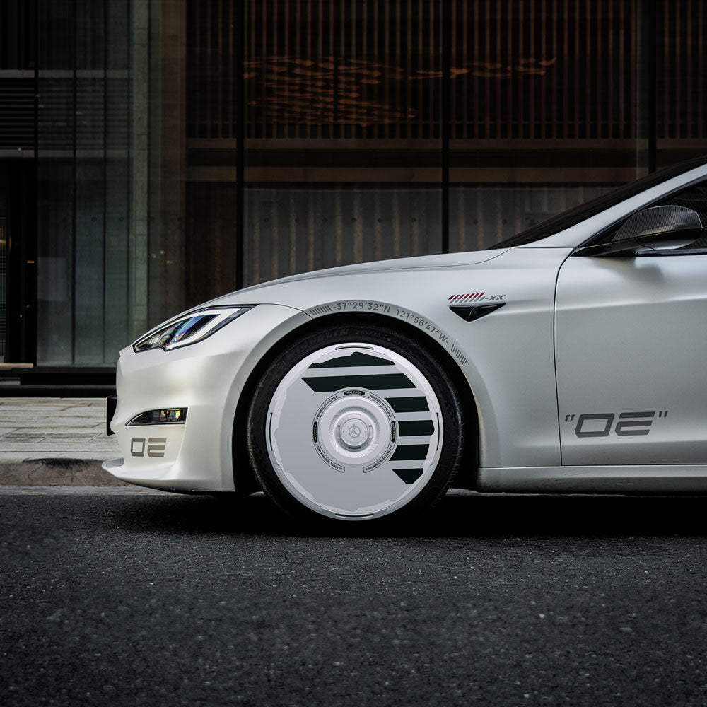 A Tesla Model S with HALODISC 2 Wheel Covers by HALOBLK Store is parked on a city street in front of a modern glass building, showcasing sleek lines and stylized 19" Slipstream wheel covers.