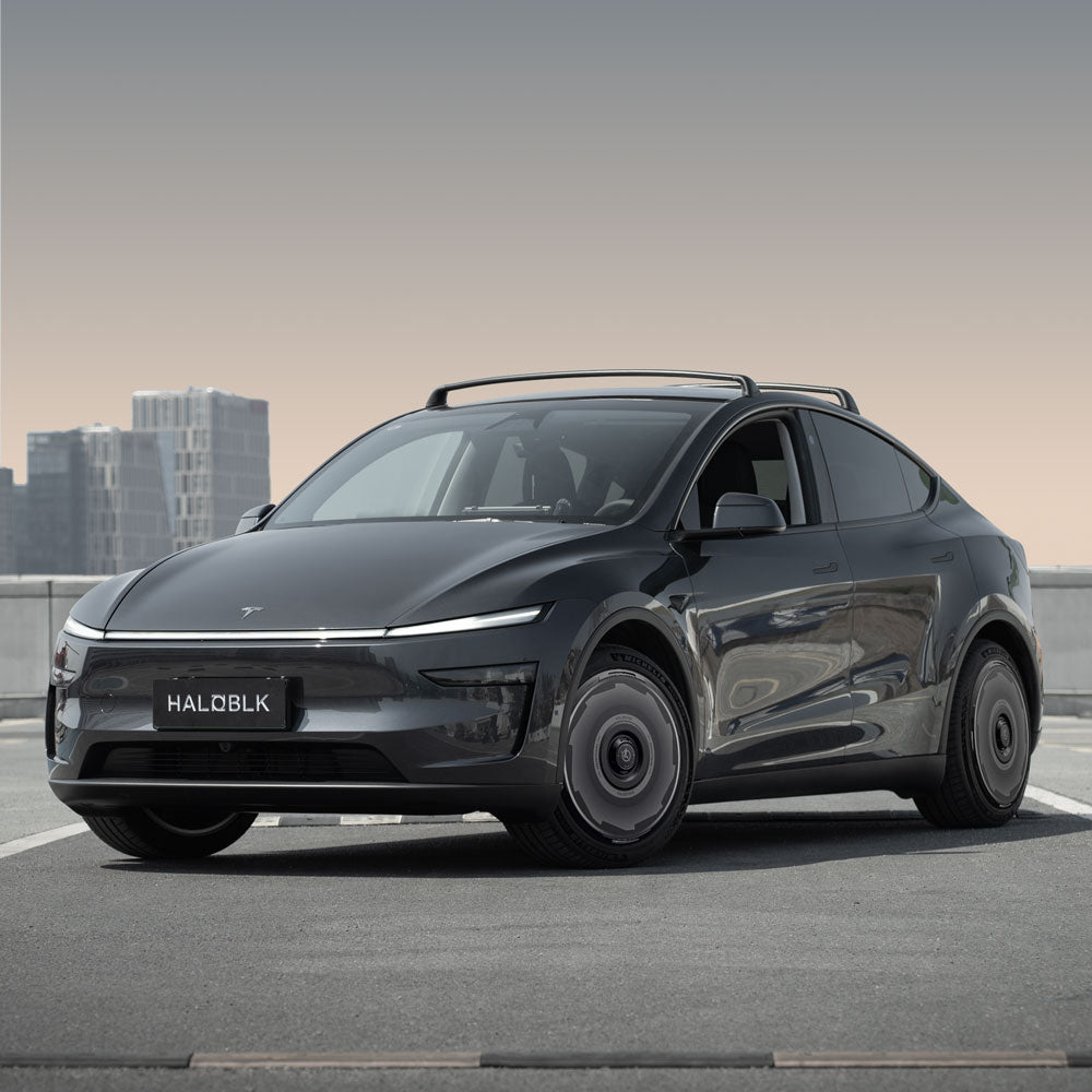 HALODISC 2 Wheel Covers by HALOBLK Store, designed for Tesla Model Y Juniper 20" Helix 2.0 Wheels (Vision-GT), are showcased on a sleek SUV with a city skyline backdrop. The license plate reads HALOBLK.