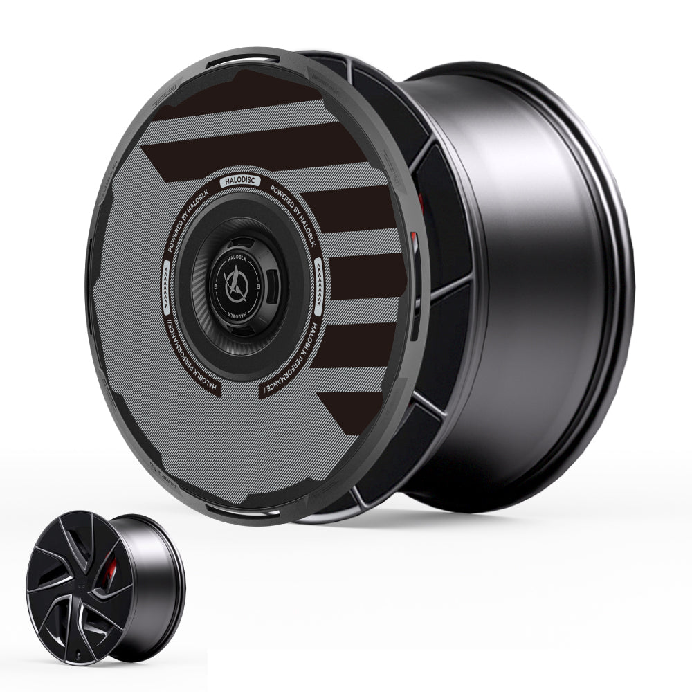 HALOBLK Store's HALODISC 2 Wheel Covers for Tesla Model S 19" Magnetite Wheels by H-Industry: two black, futuristic covers—one upright with bold diagonal stripes and central logo, one flat showing a smooth, angular spoke design.