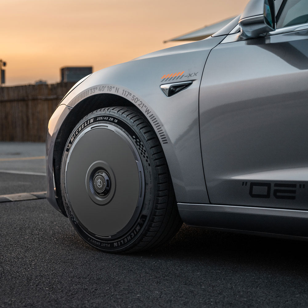A close-up of a silver Tesla Model 3 (2021–2023) with HALODISC 2 Wheel Covers by HALOBLK Store, designed for 20" Überturbine wheels. Smooth, flat covers and Michelin tires are shown alongside Tesla logo and side decals.
