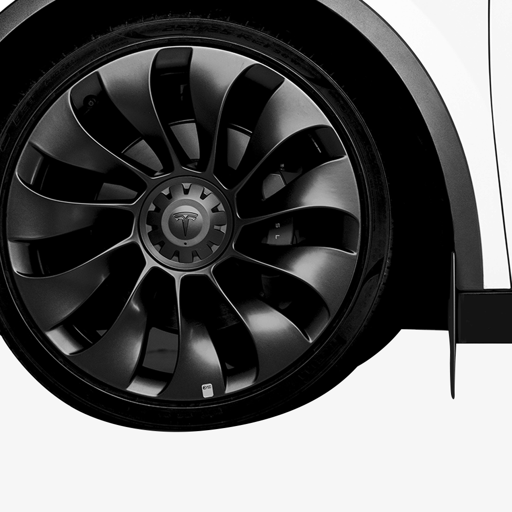 Close-up of HALOBLK Store's Model Y Mud Flaps on a white Tesla, showcasing premium protection and a sleek, modern look that complements the black alloy wheels with the Tesla logo.